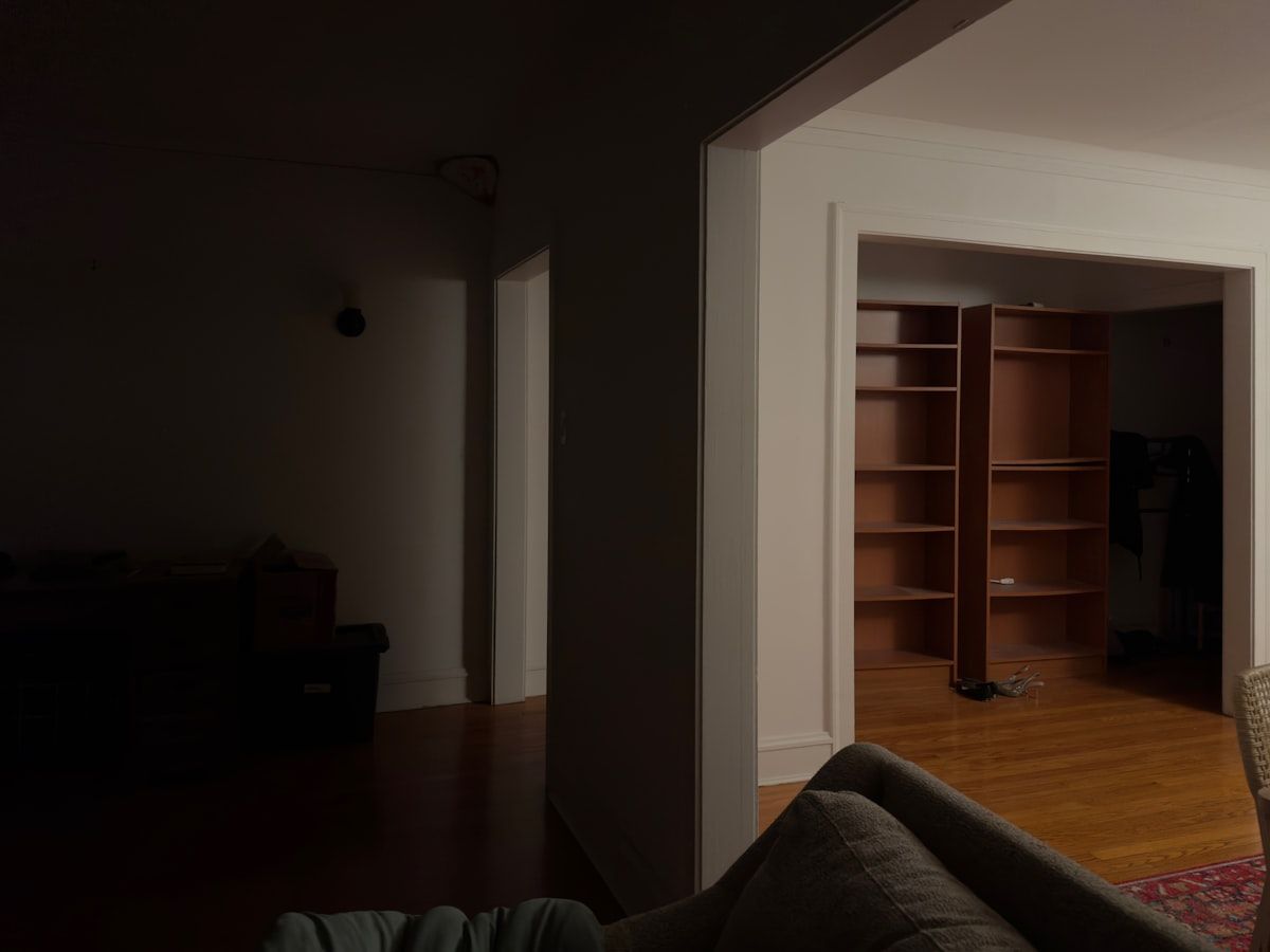 A walk-in closet floor plan shown as a realistic built-in storage room with side-by-side wardrobe sections, an L-shaped corner of shelves and hanging rods, and a narrow center aisle left open for walking between the storage walls.