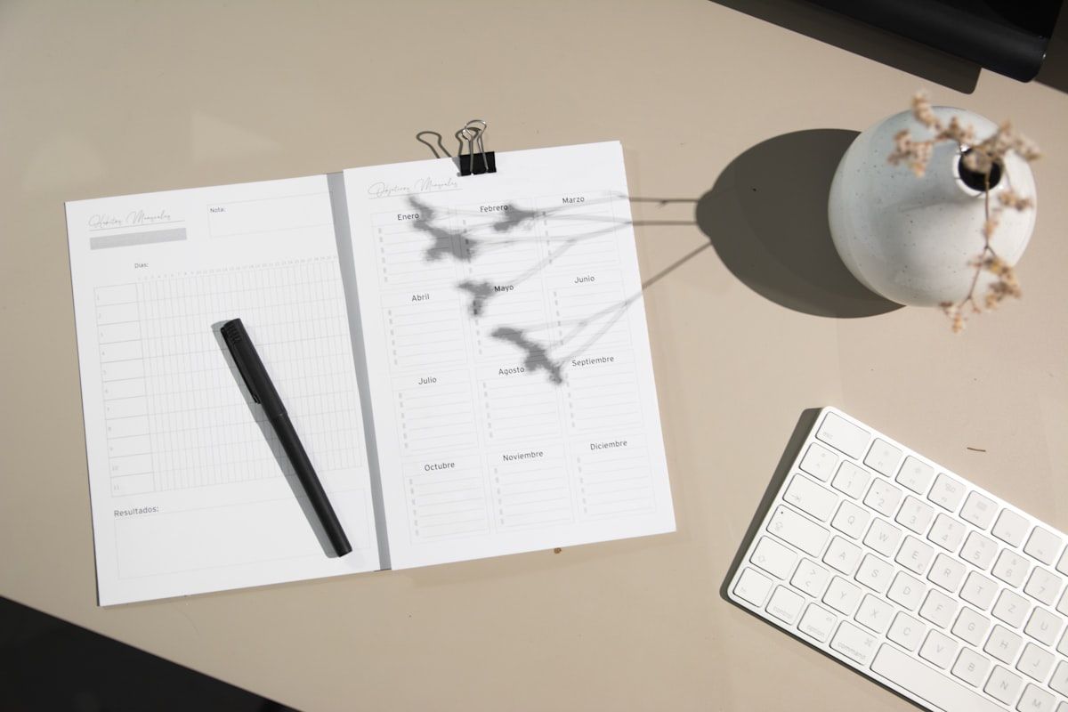A clean desk or table with a one-page closet inventory summary sheet beside printed closet photos, a notebook open to category counts and measurements, and a few material swatches laid out next to the papers for planning a redesigned closet.